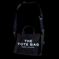 Bolsa Marc Jacobs The Tote Bag preta em lona com alça tiracolo ajustável, disponível no garimpo do madruga
