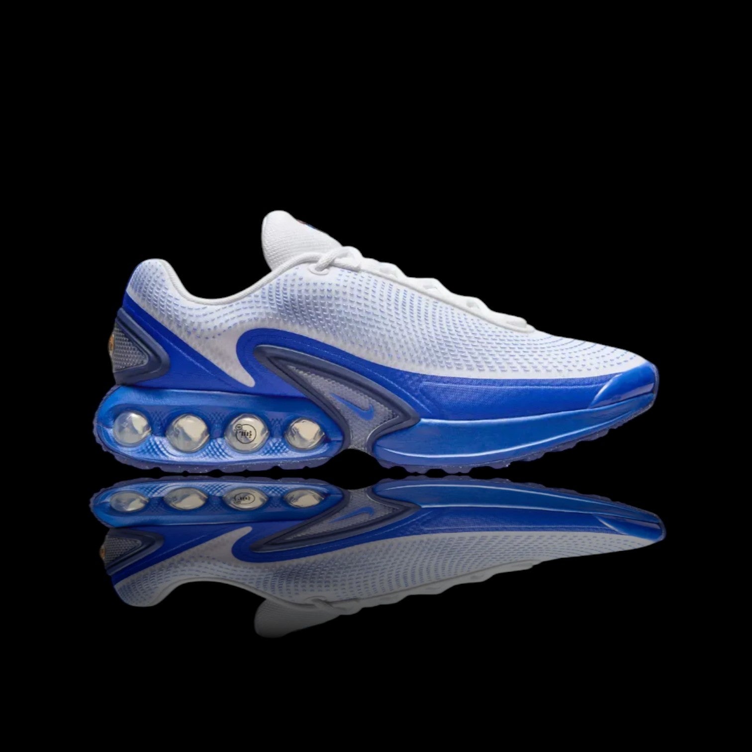 Tênis Air Max Dn Platinum Royale Blue branco e azul com amortecimento visível na sola e detalhes em mesh.