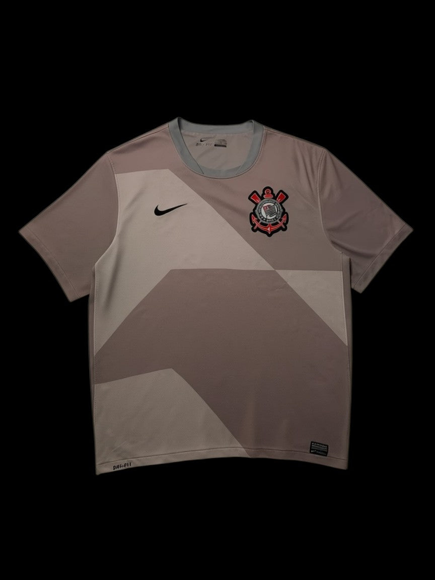 Camisa do Corinthians Nike 2012, tamanho GG, em poliéster, com escudo do time e logo Nike. Cor predominante cinza com detalhes em tons mais claros.
