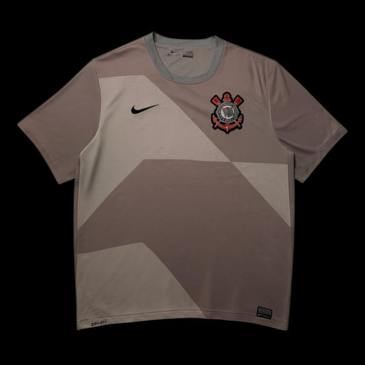 Camisa do Corinthians Nike 2012, tamanho GG, em poliéster, com escudo do time e logo Nike. Cor predominante cinza com detalhes em tons mais claros.