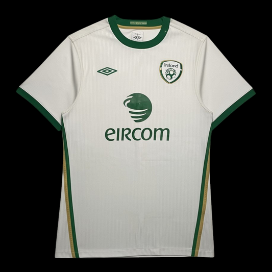Camisa de futebol Irlanda 2010 Umbro branca com detalhes em verde, patrocinada pela garimpo do madruga