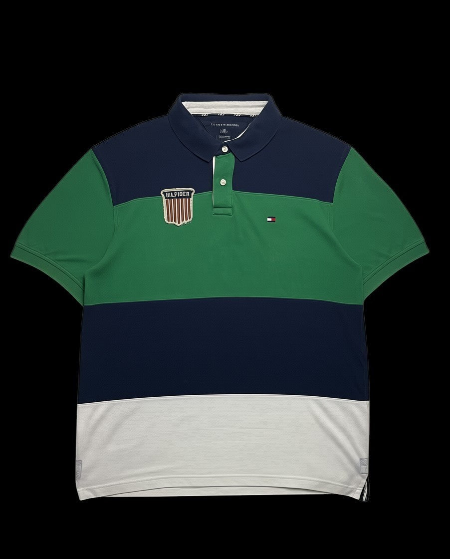 Camisa polo Tommy Hilfiger color block azul marinho, verde e branca com patch "HILFIGER" no peito.