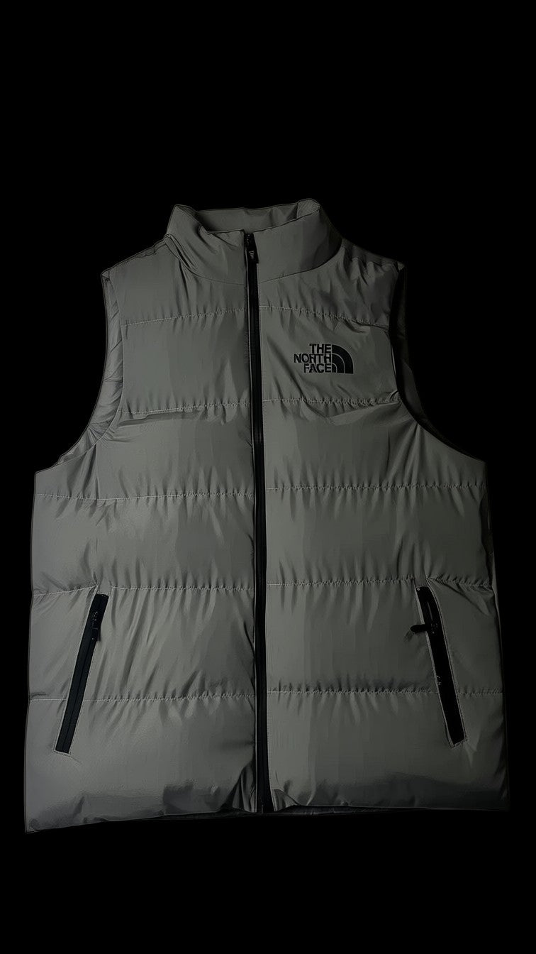 Colete acolchoado cinza The North Face tamanho G com zíper frontal e logo preto no peito.
