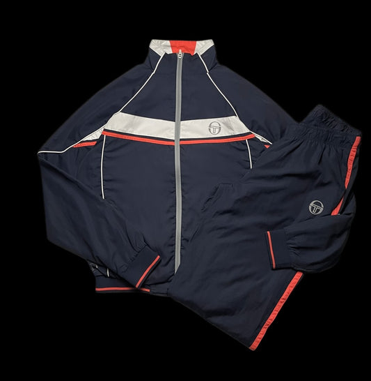 Conjunto de agasalho azul marinho da Sergio Tacchini com detalhes em branco e laranja, tamanho M. Calça com listras laterais.