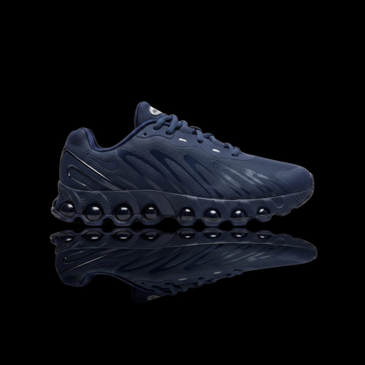 Tênis Nike Air Max Dn8 azul marinho com solado de bolhas e swoosh lateral prateado.